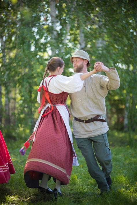 man and woman in traditional russian clothes are performing russian
