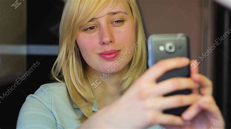 european blonde girl with different eyes takes selfie on phone