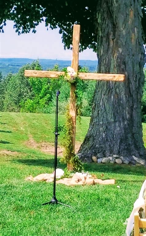 wooden cross sitting  top   lush green field    large tree