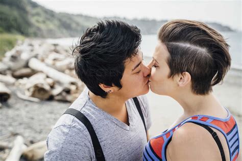 pregnant lesbian couple kissing on beach blef02849