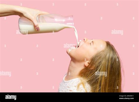Happy Girl Drinking Milk From Bottle Isolated On Pink Background Milk