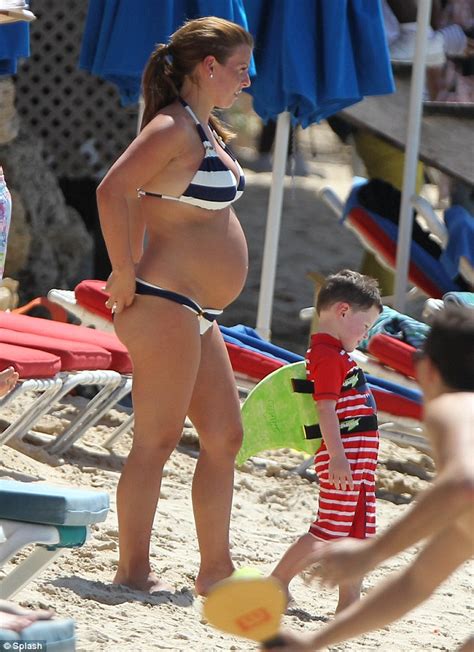 kai rooney splashes about in the water on barbados beach