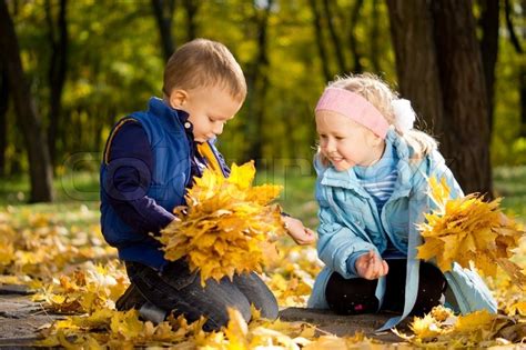 attractive little brother and sister in autumn woodland