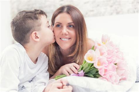 Happy Mother`s Day Concept Mom With Son On Bed With T And Tulips