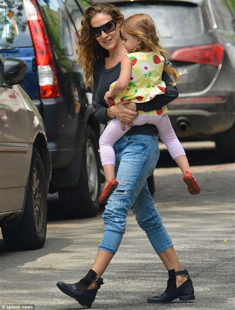 sarah jessica parker holds her daughters in her arms as she goes for a stroll in new york