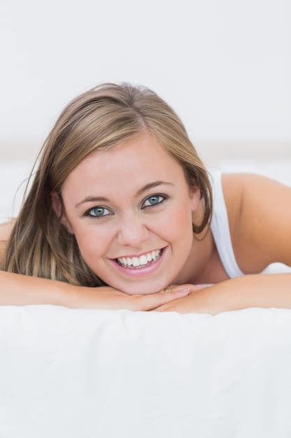 premium photo smiling blond woman lying on her bed