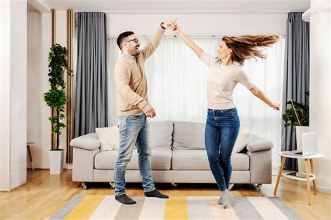 Premium Photo A Playful Couple Dancing Together At Their New Home