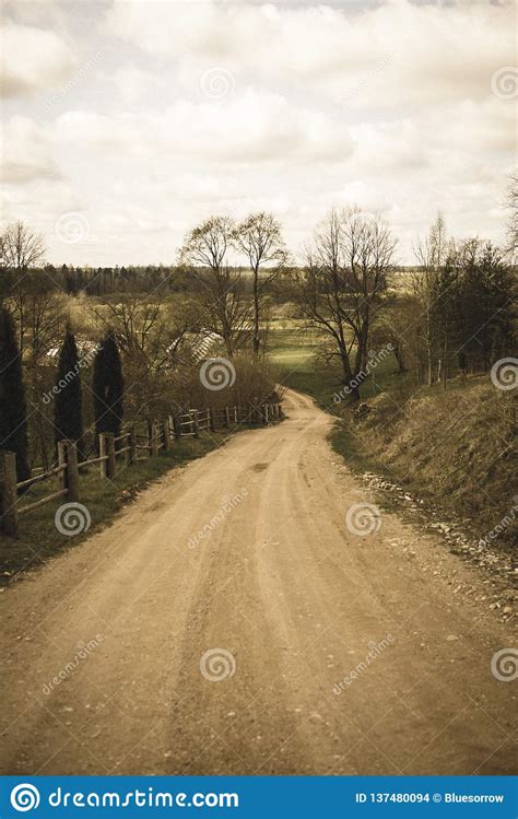 het grintweg van het land met oud en gebroken asfalt uitstekende retro ziet eruit stock foto