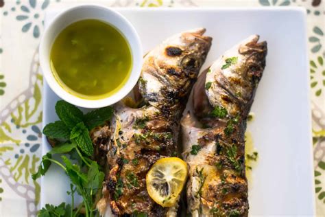 Grilled Branzino With Lemon Slices Fresh Herbs And Citrus Olive Oil