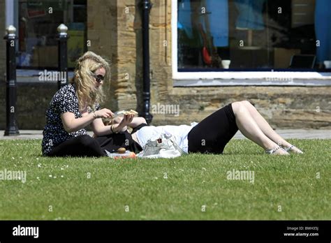Two English Girls Enjoy A Picnic On The Grass During The Warm Summer