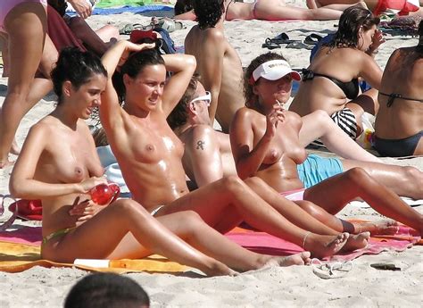 nude friends play around at a public beach pichunter