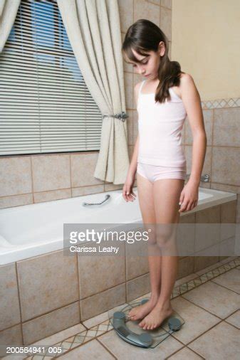 girl standing on scales in bathroom photo getty images