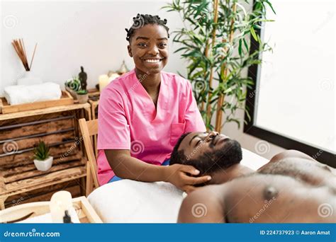 Young Physiotherapist Woman Giving Head Massage To African American Man