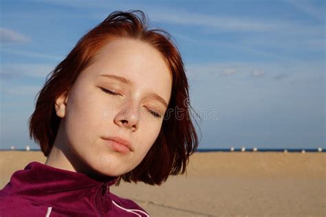 Portrait Of A Red Haired Teenage Girl With Closed Eyes On An Empty