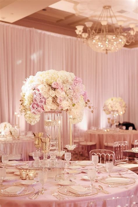 tall glass vase wedding centerpiece filled in with white and blush flowers