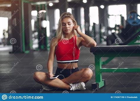 sports blonde in a sportswear have a rest in a gym stock