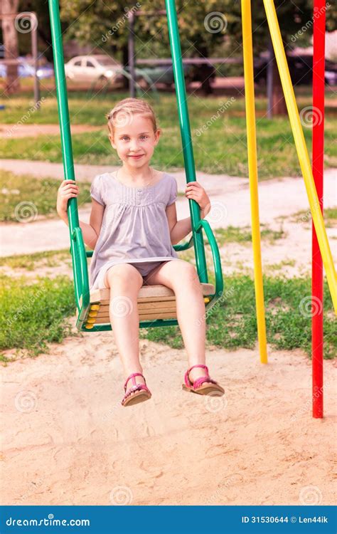 Schönes Kleines Mädchen Auf Schwingen Im Freien Im Spielplatz Stockfoto