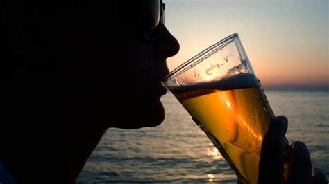 Woman Drinking Beer On Beach At Sunset By Grey Coast Media Videohive