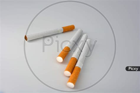 image of many white cigarettes with a brown filter chaotic arranged on