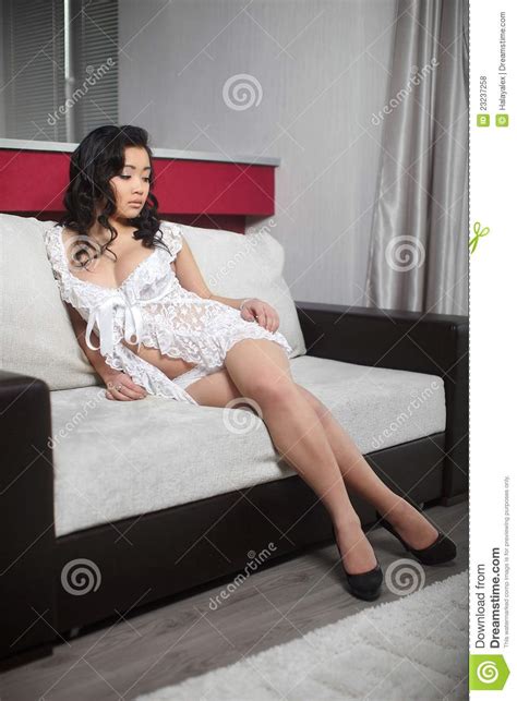 sexy chinese woman in white peignoir in interior royalty free stock