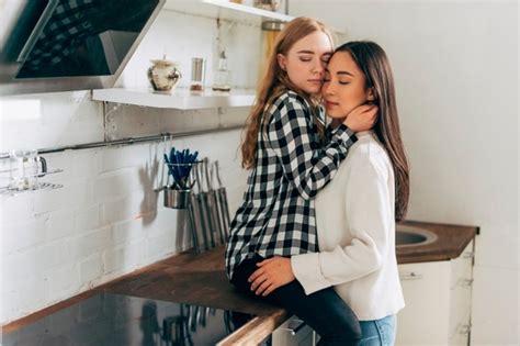 free photo beautiful lesbian couple embracing in kitchen
