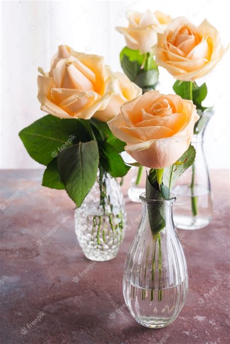 Premium Photo Beautiful Fresh Cut Beige Roses In Glass Vase On Stone