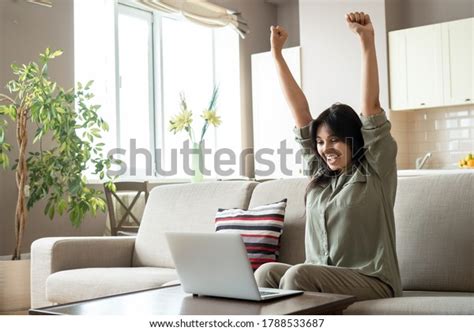 ผู้หญิงอินเดียตื่นเต้นฉลองความสำเร็จออนไลน์ชนะมองไปที่แล็ปท็อปที่บ้านมี