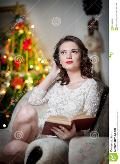 Beautiful Sexy Woman With Xmas Tree In Background Reading