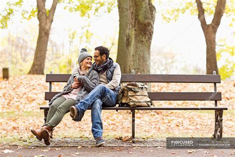 smiling couple sitting  park bench happiness leisure stock photo