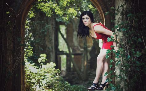 woman outdoors red dress high heels nature bent over