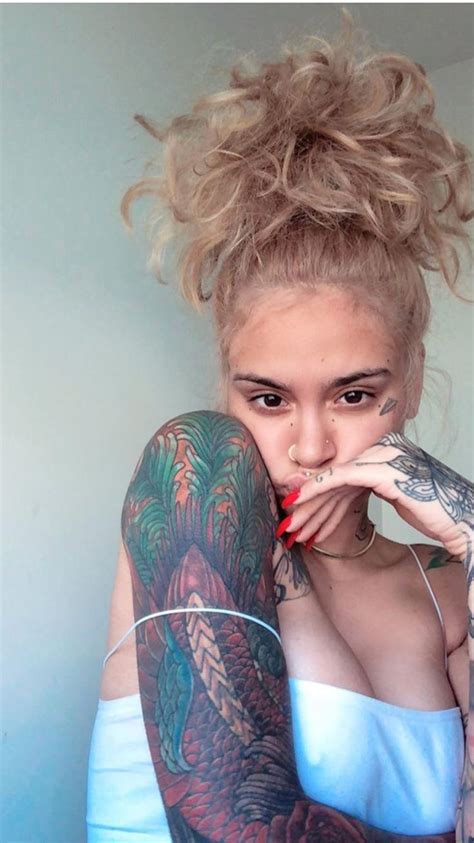 a woman with tattoos on her arm posing for the camera