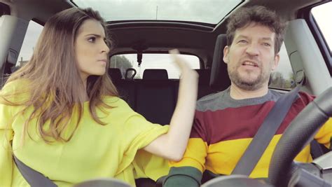 happy couple having fun making stupid faces in car dancing looking camera slow motion stock