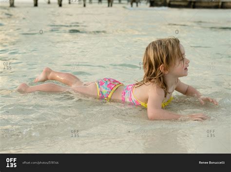 girl lying  stomach  water  beach stock photo offset