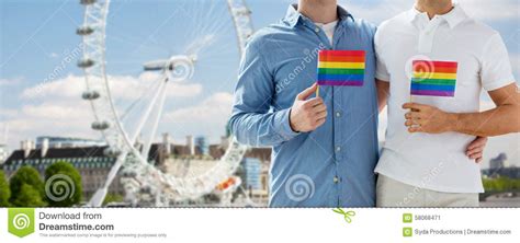 close up of male gay couple with rainbow flags editorial photo image