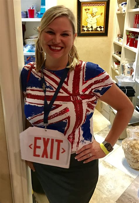 woman standing   kitchen holding  exit sign   british flag painted
