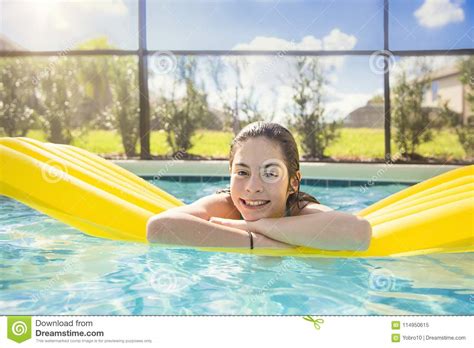 adolescente feliz que flota en una piscina al aire libre