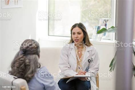 mid adult female gynecologist meets with the mature woman at the