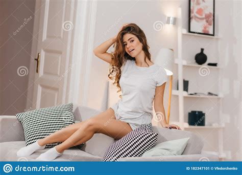 Sensual Woman In White Socks Posing On Sofa And Touching Her Long Hair