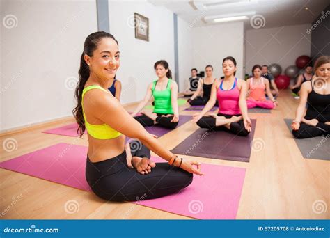 Yoga Instructor Helping Pregnant Woman To Do Warrior Asana Stock