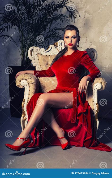 Magnificent Young Woman In Luxurious Red Dress And Precious Jewelery Is