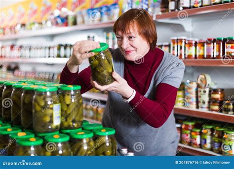 female choosing canned jar  cucumbers stock photo image  goods female