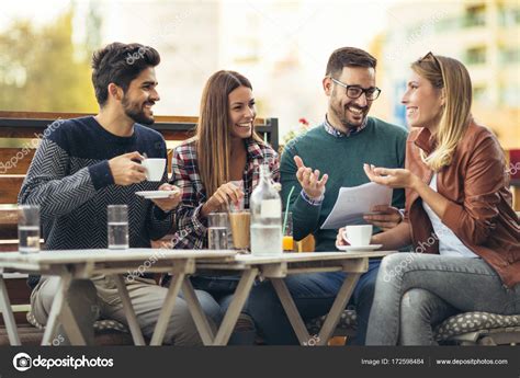 grupo de cuatro amigos divirtiendose tomando  cafe juntos dos mujeres  fotografia de stock