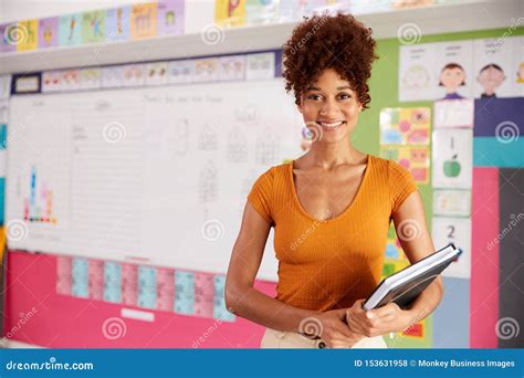 Portrait Of Female Elementary School Teacher Standing In Classroom