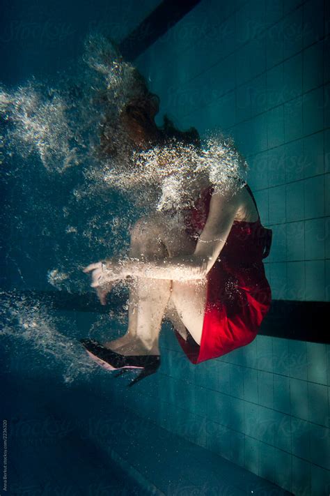 woman in red dress underwater wearing fashion shoes with high heels