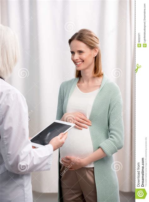 Doctor And Pregnant Woman Discussing Pregnancy Process Together In