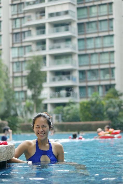 Asian Chinese Woman In Swimsuit Smiling Cheeky At Swimming Pool Stock