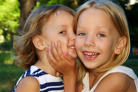 fotos de stock de dos hermanas abrazándose y besándose