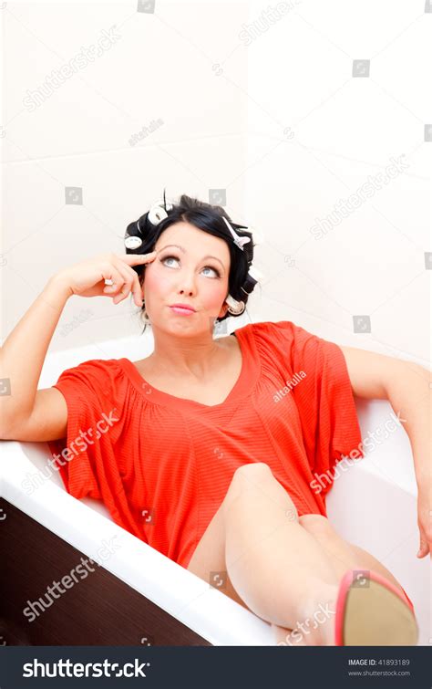 thinking creative modern housewife with dress and high heels lying sexy in bath tube waiting and