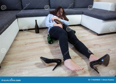 drunk woman laying on the floor after huge party with some bottles of