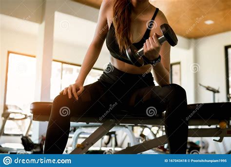 fitness woman doing exercise workout dumbbell at gym healthy and